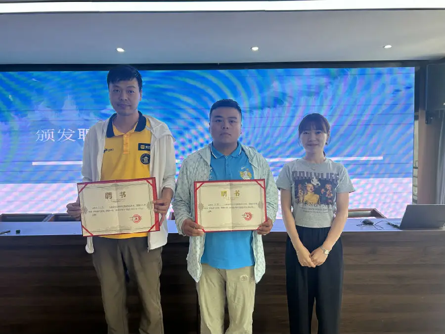 海湾社区党总支副书记郭佳丽（右一）给骑手志愿服务队颁发聘书。（周赟摄）